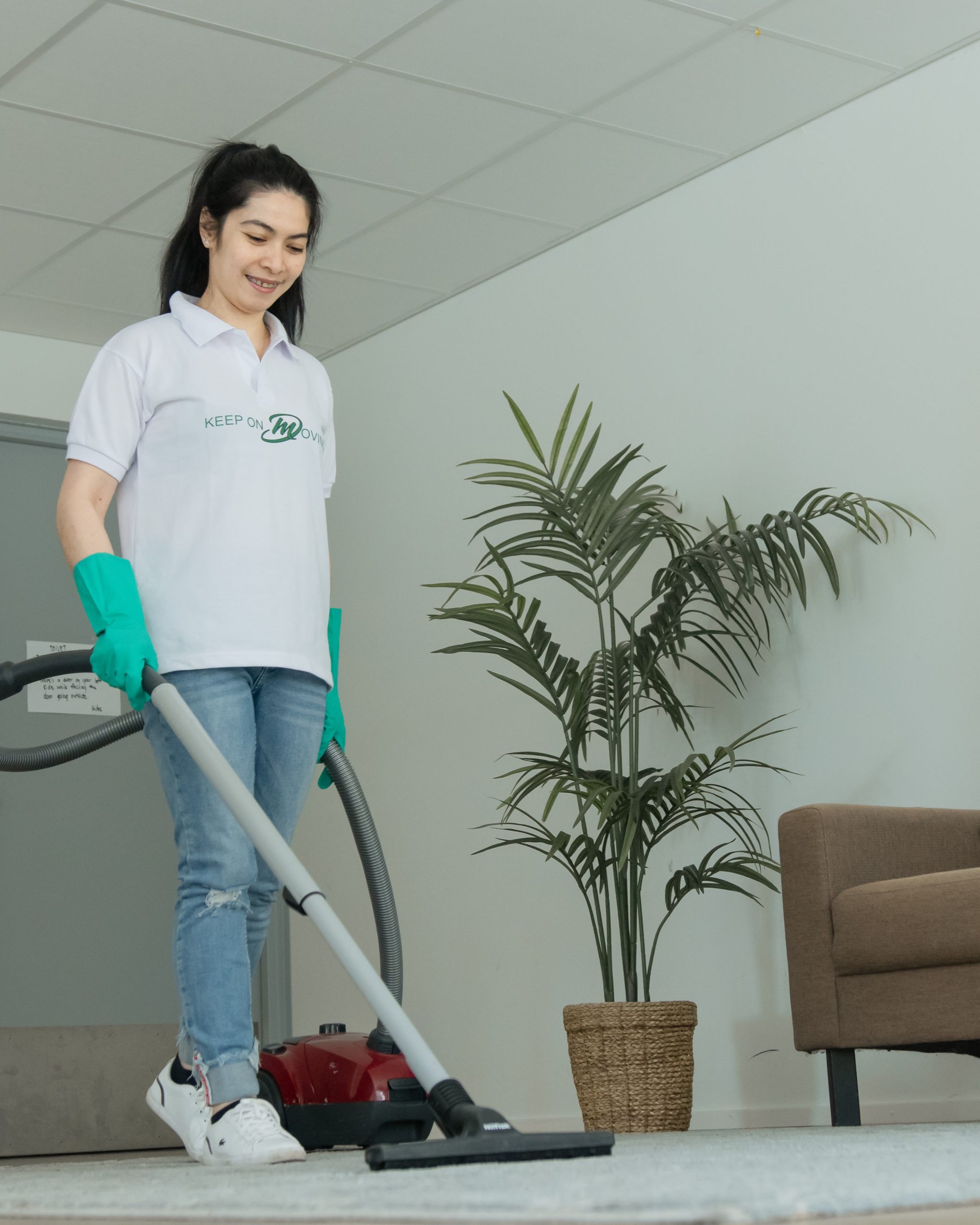 Mik Oy professional cleaner vacuuming carpeted office floor with commercial equipment in a Helsinki business space, Finland