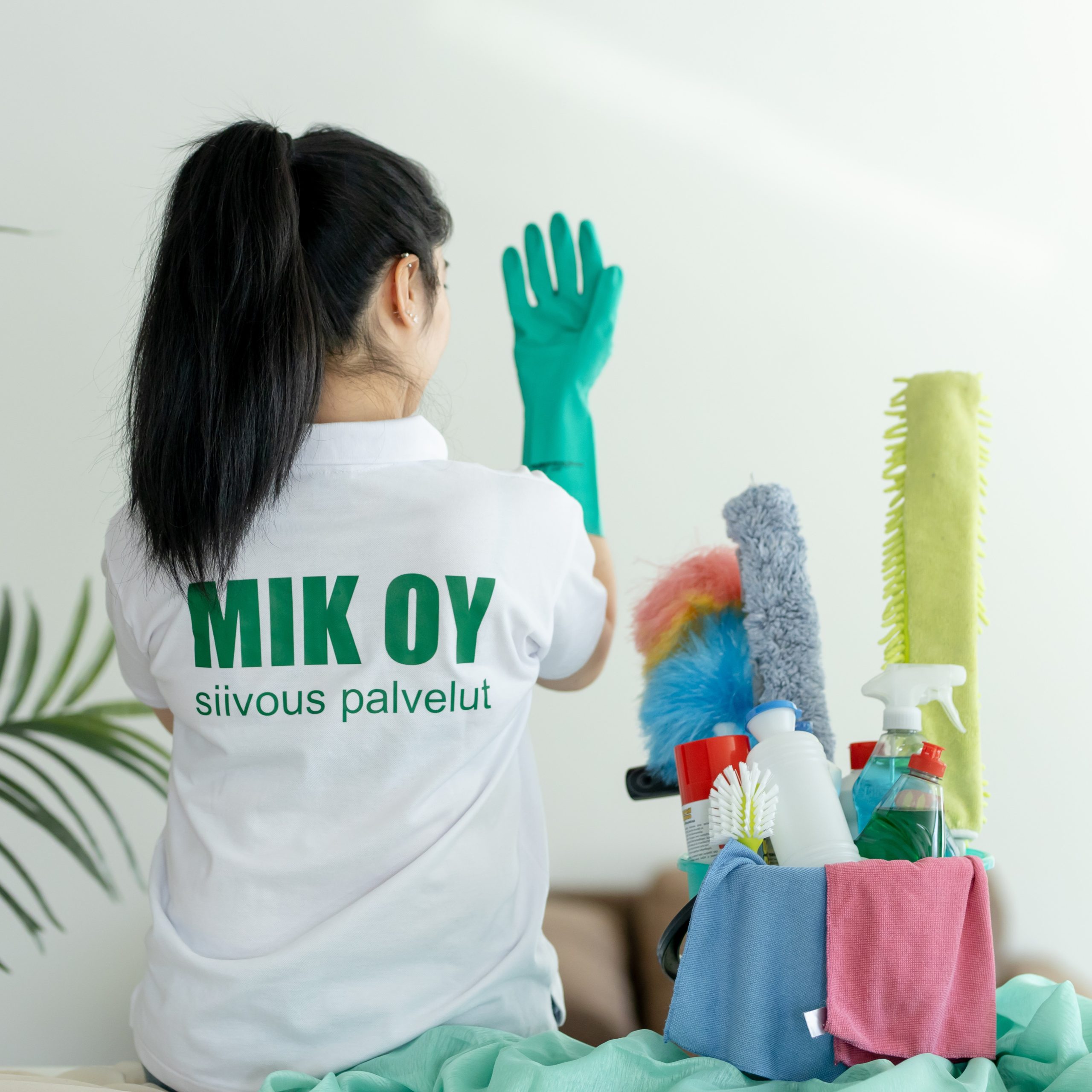 Mik Oy branded cleaning crew member in Siivous Palvelut uniform with professional dusters, microfiber cloths, and eco-friendly cleaning supplies in Helsinki, Finland