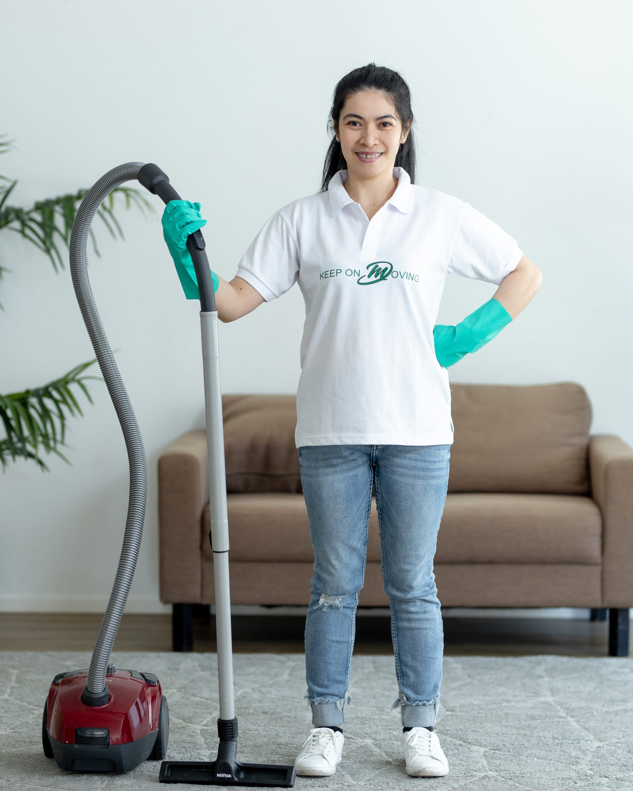 Mik Oy professional cleaner in uniform holding a vacuum, ready to start a residential move-out cleaning service in Helsinki, Finland