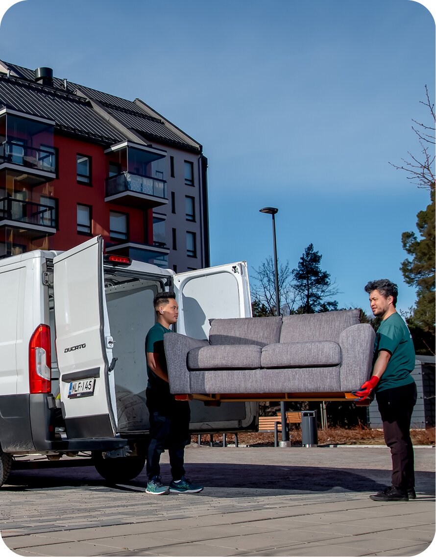 Mik Oy moving team carrying a sofa to the van in Helsinki -- professional moving and delivery services across Espoo, Vantaa and Uusimaa